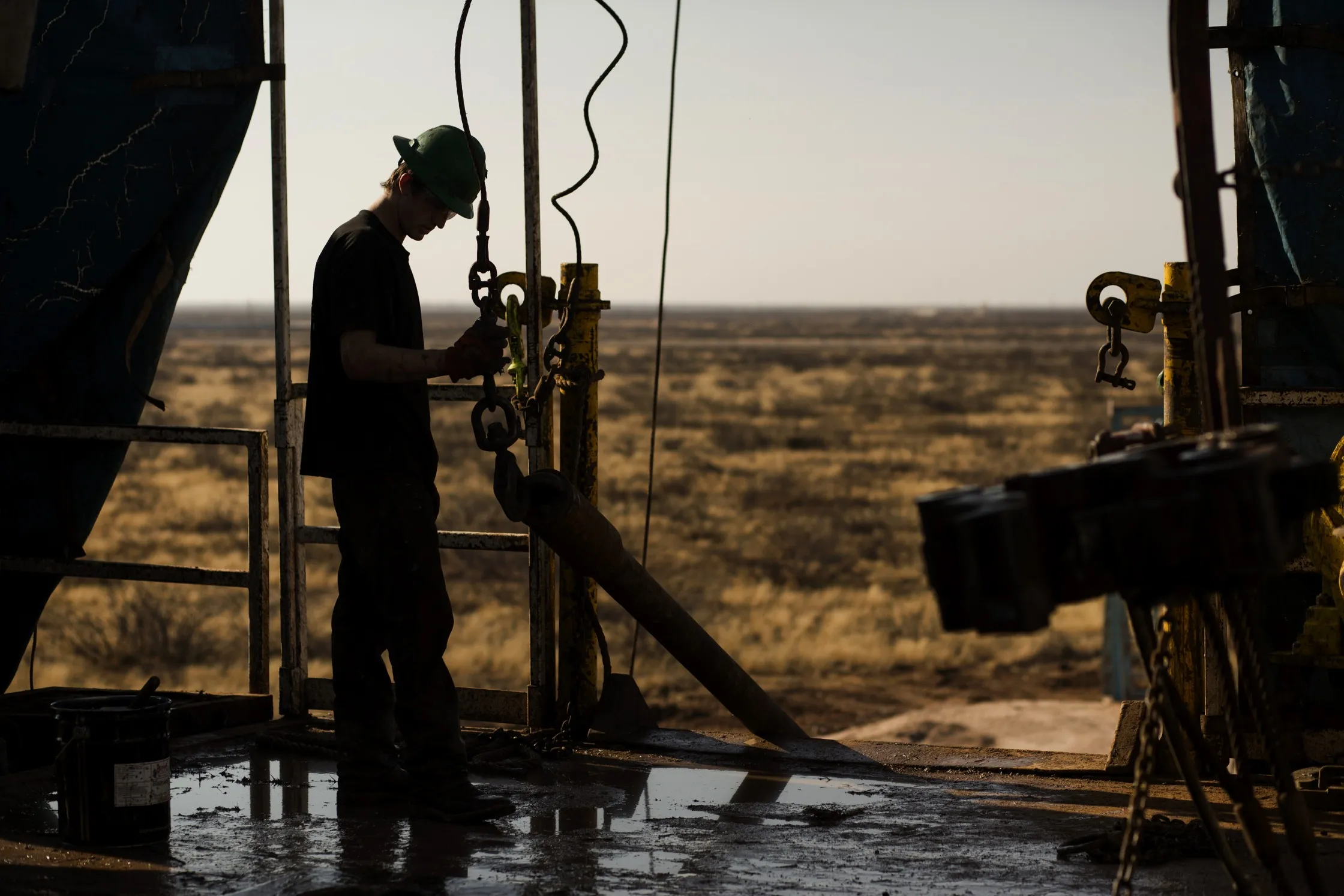 A worker waits to connect a drill bit on a drilling rig outside&nbsp;Midland, Texas.