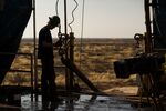 A worker waits to connect a drill bit on a drilling rig outside Midland, Texas.