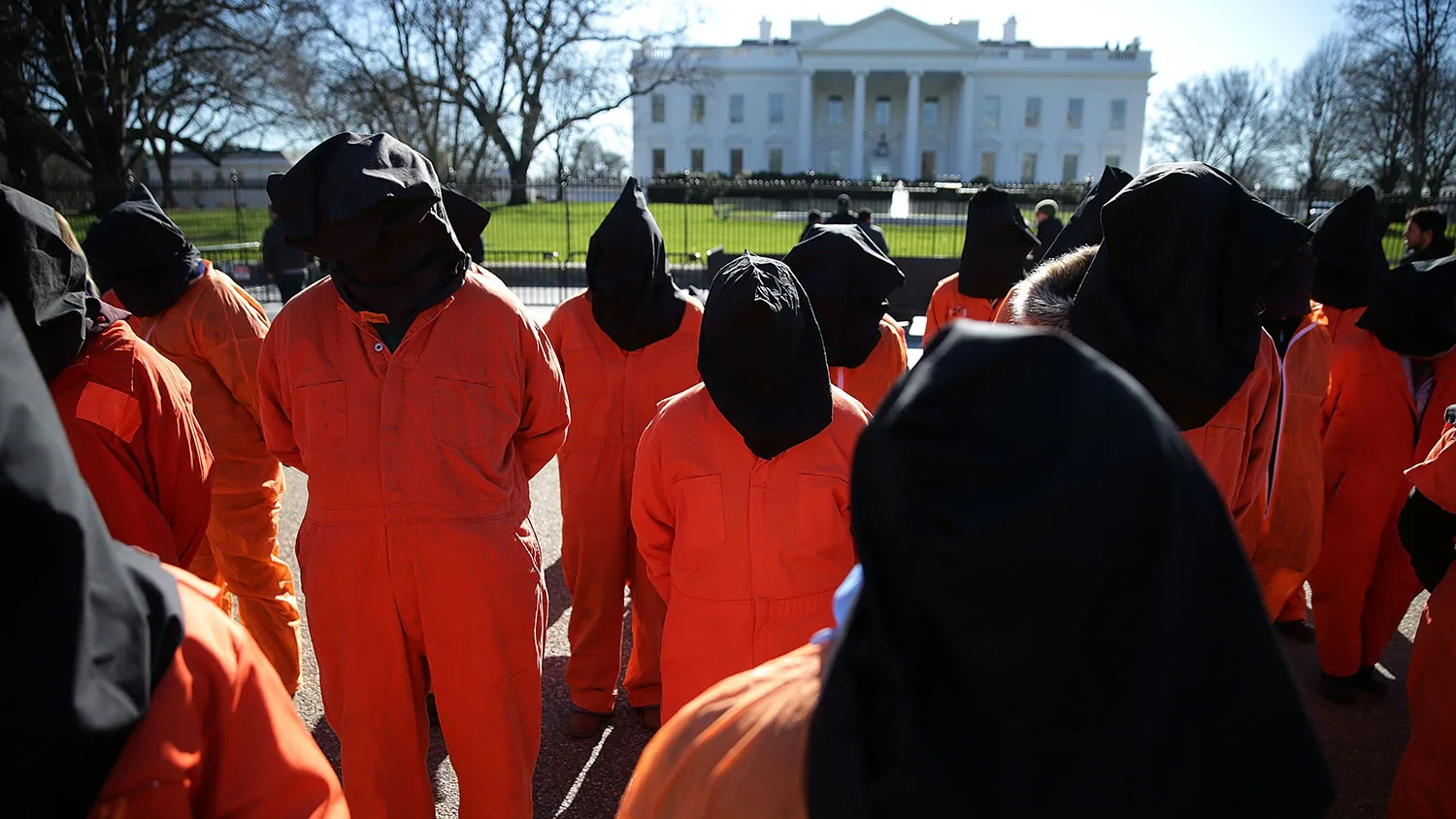 Activists in orange jump suits participate in a rally in front of the White House in Washington to demand the closure of the Guantanamo Bay detention camp on Jan. 11, 2016.
