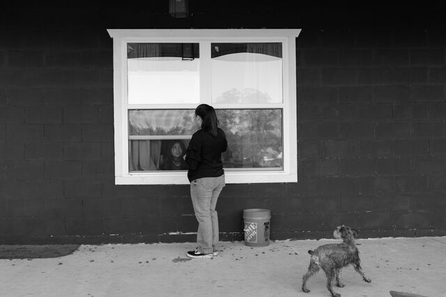 Nunez talks to her daughter Isabelle through the window of the house. 