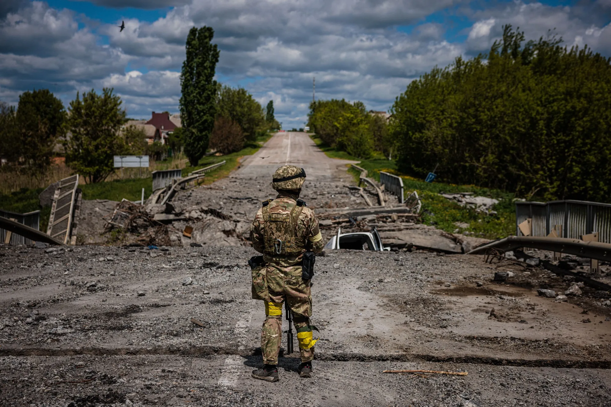 A soldier of the Kraken Ukrainian special forces unit observes the area at a destroyed bridge north of Kharkiv.