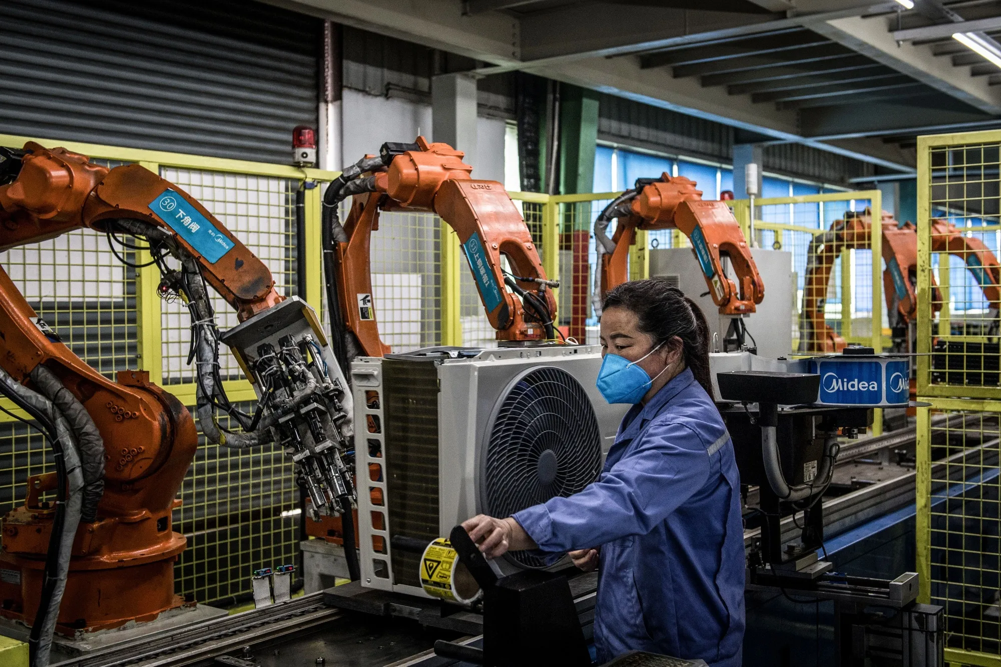 A person wearing a protective mask works&nbsp;on an air conditioner production line in Wuhan, China, on March 25.