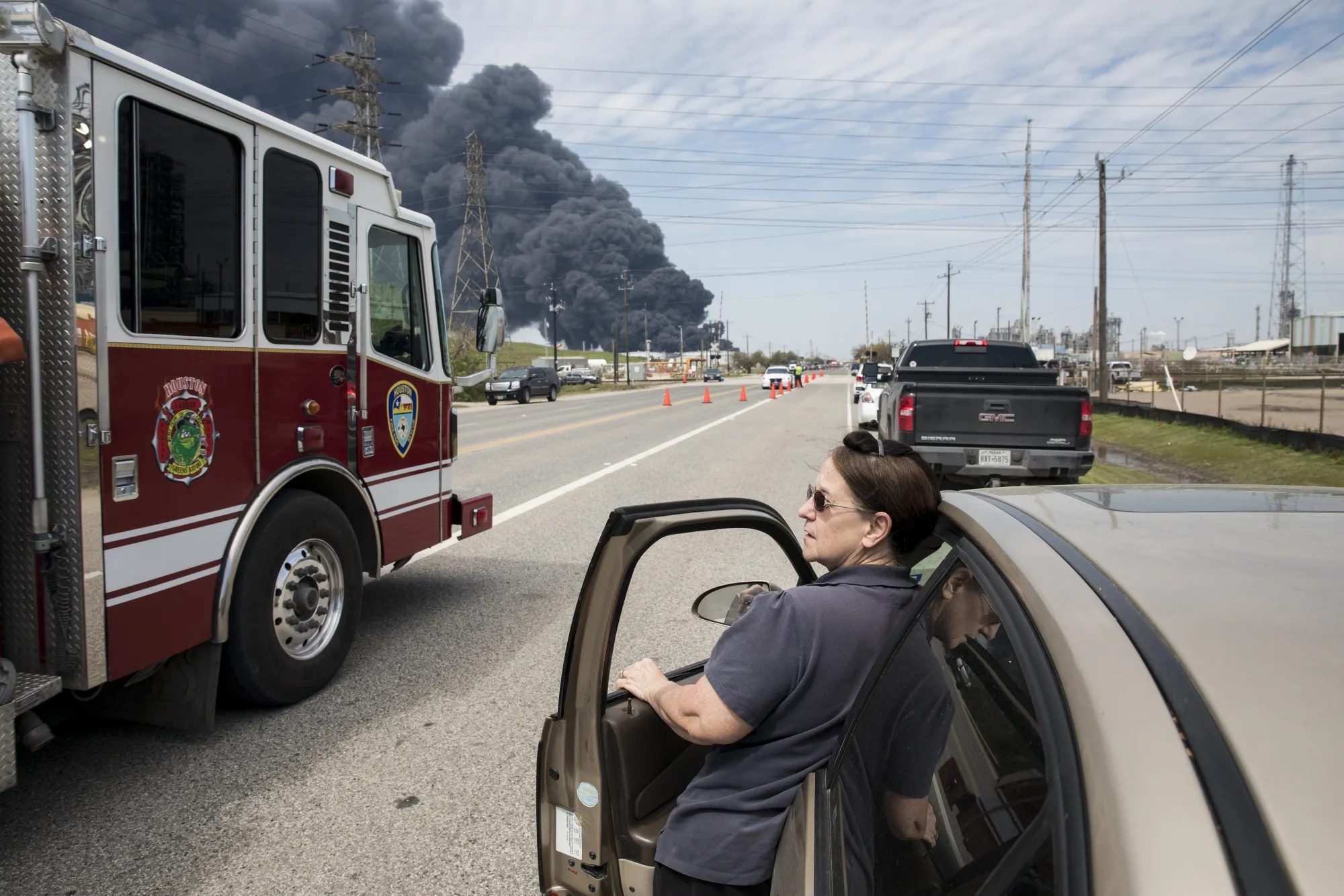A local resident looks on as a fire truck arrives to the fire at the Intercontinental Terminals Co petrochemical storage site in Deer Park, Texas on March 19, 2019.