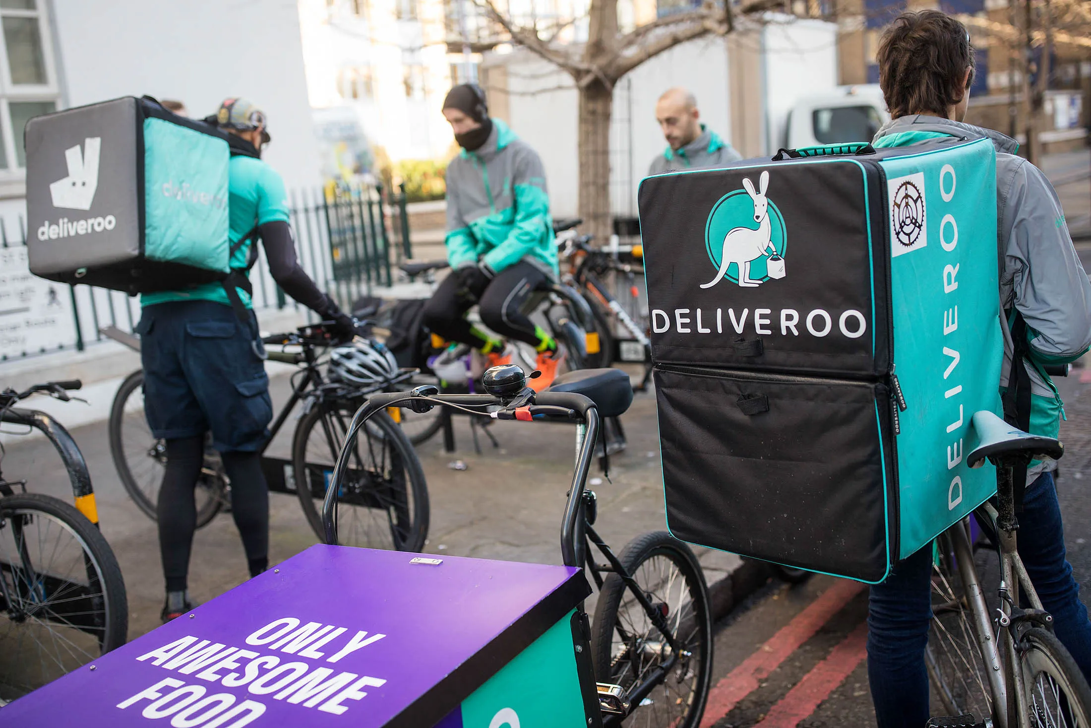 Food delivery cycle couriers chat as they wait for orders from Deliveroo in London, on Dec. 22, 2016.
