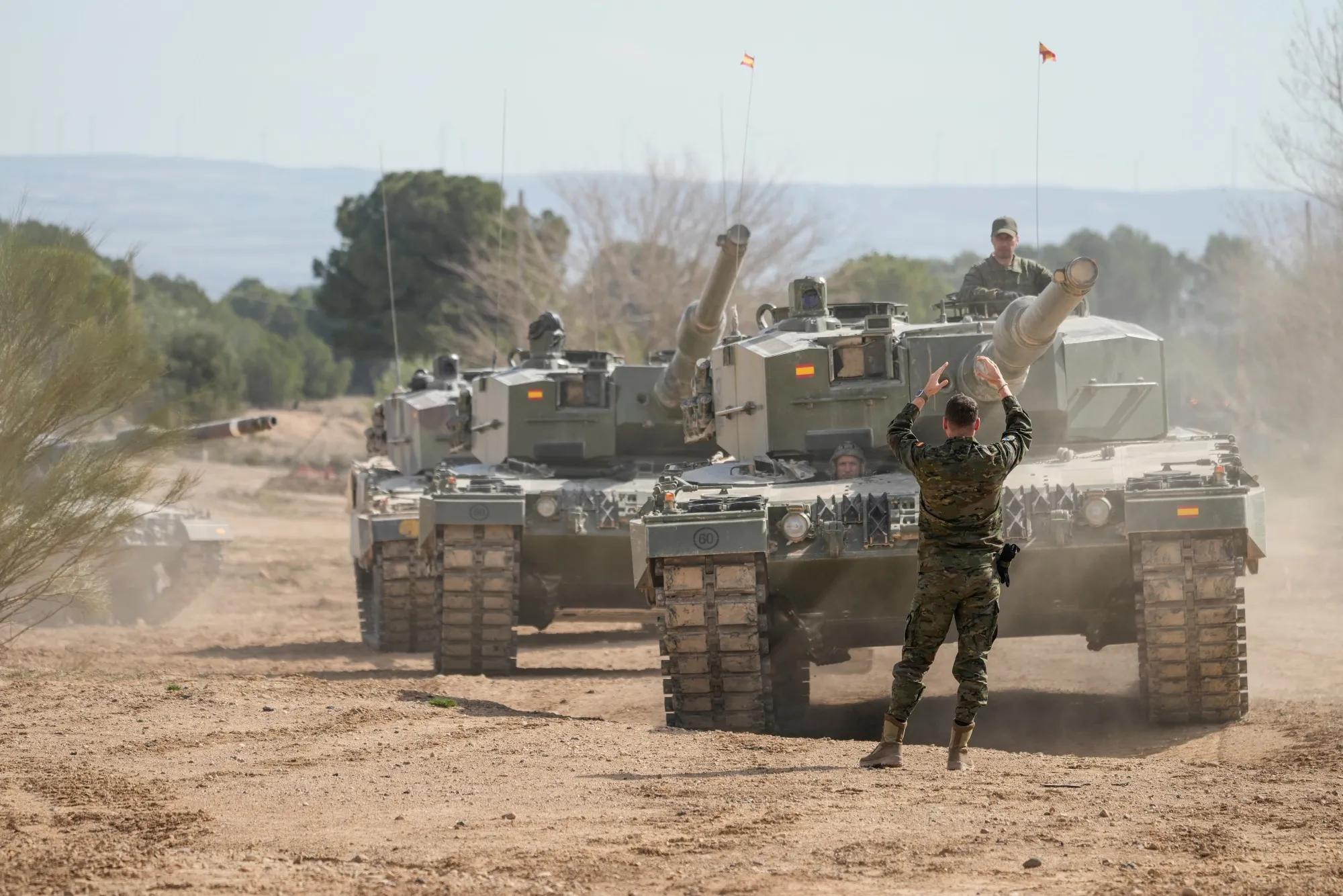 A Spanish soldier directs a Leopard 2A4 tank operated by Ukrainian military personnel during a training exercise in&nbsp;Spain
