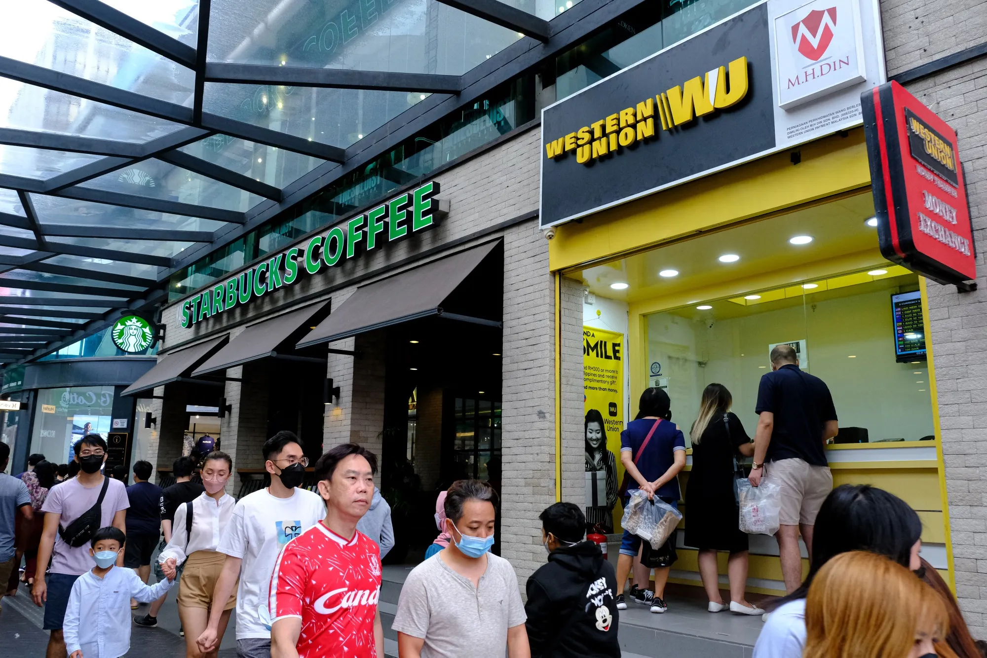 Pedestrians pass a&nbsp;Starbucks Corp. restaurant in Kuala Lumpur.&nbsp;