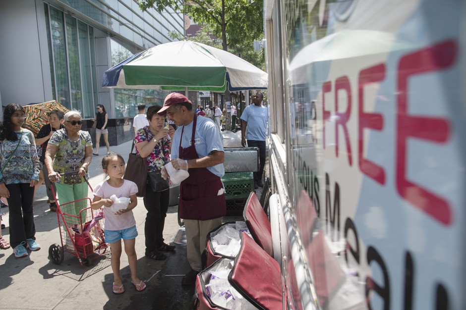 A child collects a free summer meal from a truck in the Flushing neighborhood of Queens, New York.