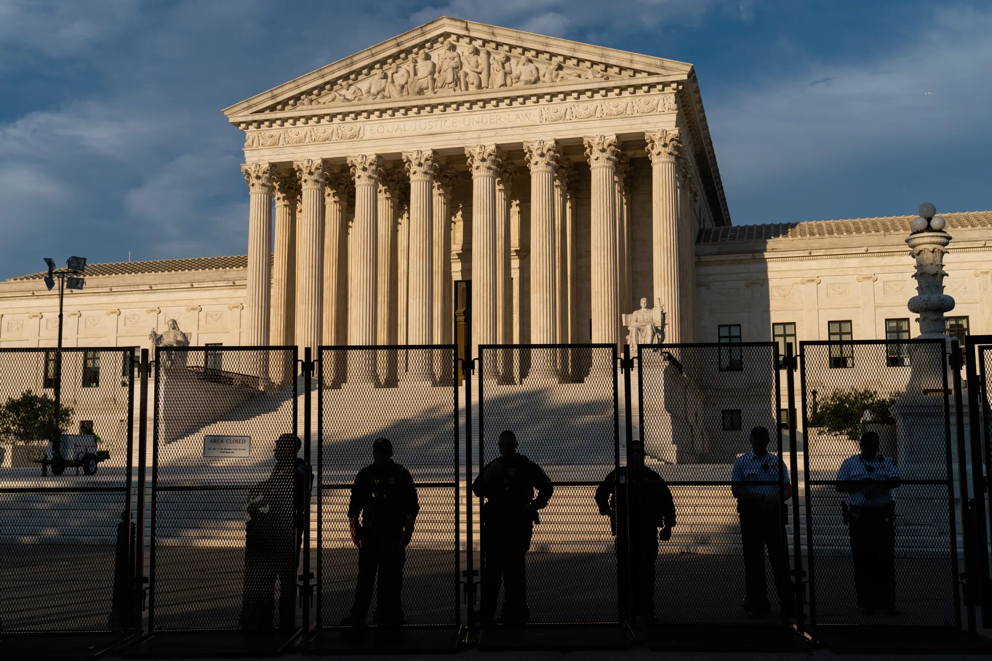 Law enforcement officers watch protesters from behind security fencing near the US Supreme Court in Washington, D.C.,&nbsp;on&nbsp;June 27