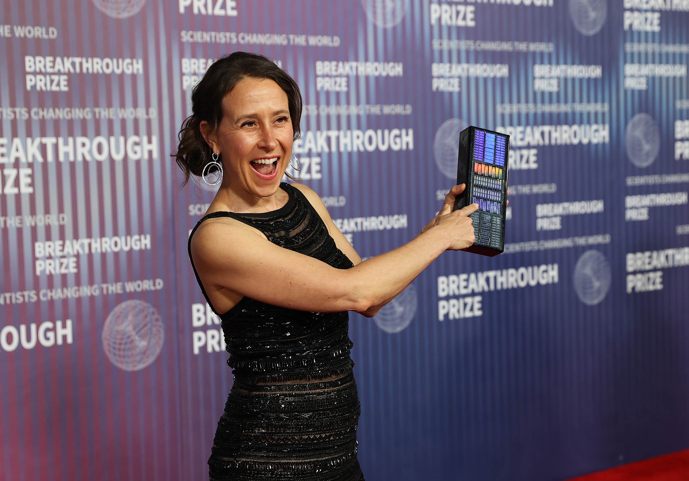 Wojcicki shows off a purse printed with a DNA microarray at the Breakthrough Prize ceremony in April.