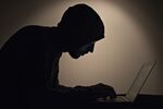 The silhouette of a man is seen typing on a laptop computer an arranged photograph taken in Tiskilwa, Illinois, U.S.