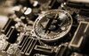 A coin representing Bitcoin cryptocurrency sits on a computer circuit board in this arranged photograph in London, U.K., on Tuesday, Feb. 6, 2018.