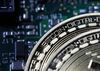 Two coins representing Bitcoin cryptocurrency sit on a computer circuit board in this arranged photograph in London, U.K.