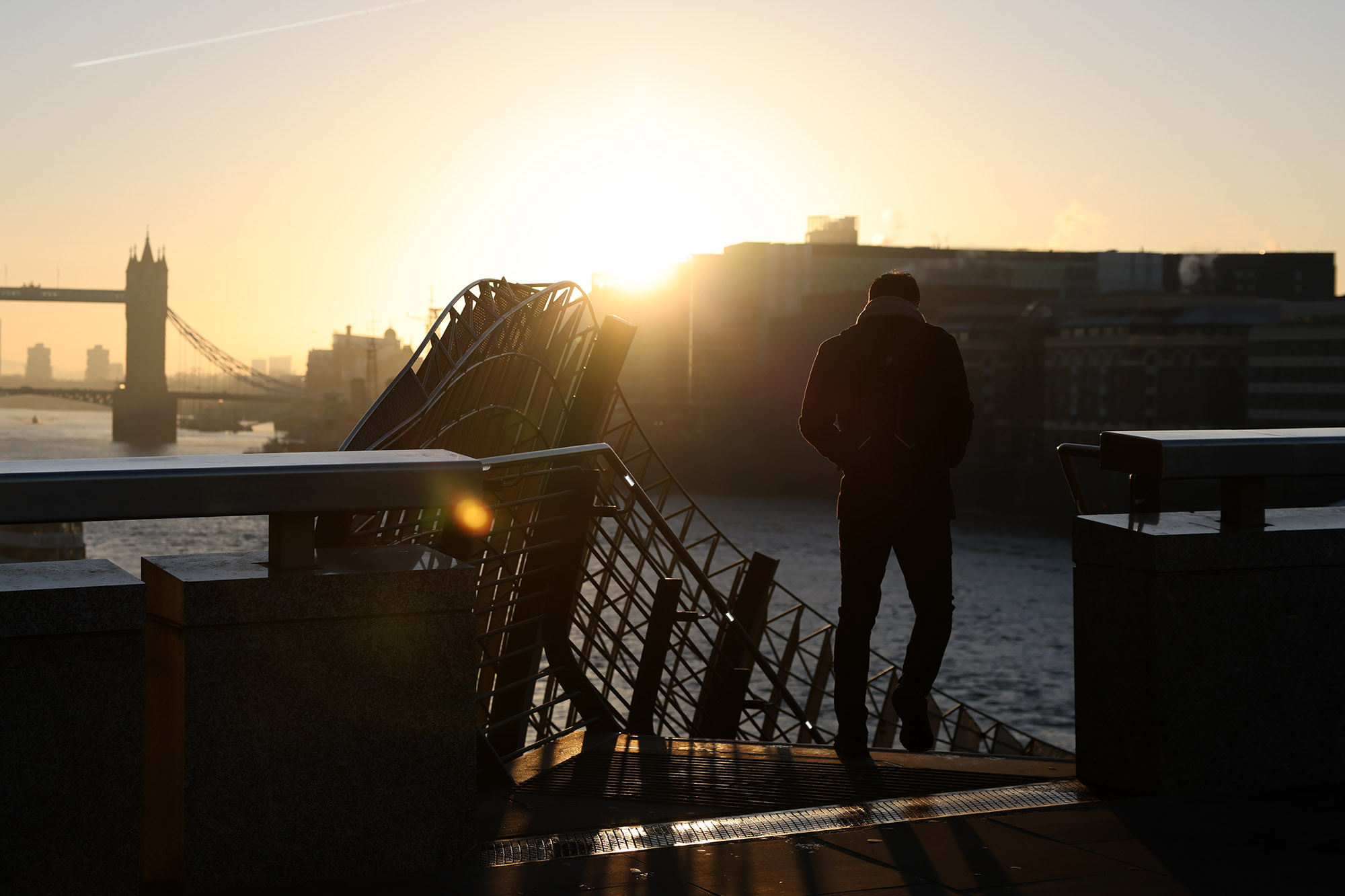 A morning commuter heads towards the Thames Path from London Bridge in the City of London.