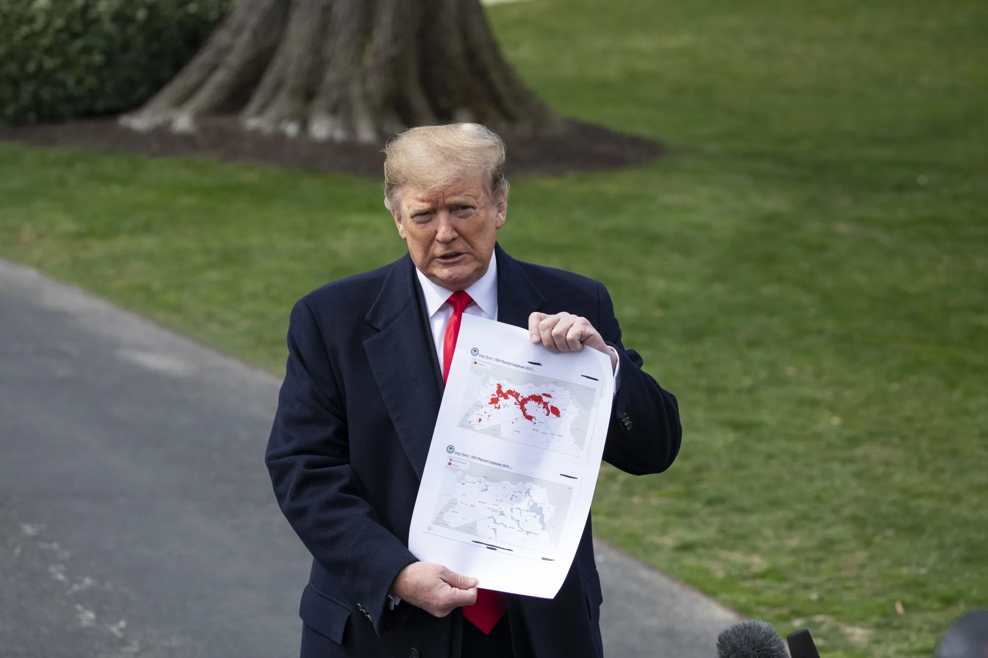 Donald Trump speaks to members of the media while holding a map of Syria on the South Lawn of the White House in Washington, D.C. on March 20, 2019.