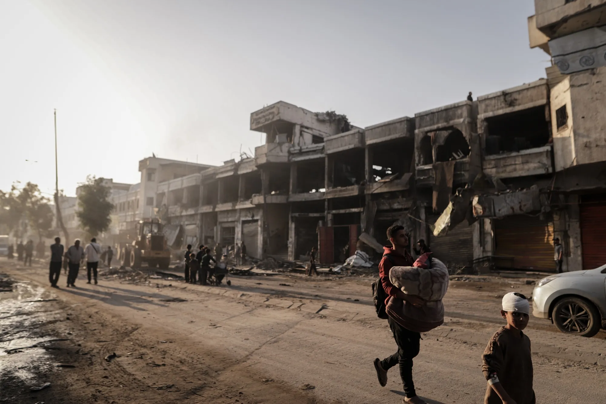 Palestinians pass a damaged building following an Israeli airstrike in the Al-Zaytoun neighborhood of Gaza City, Gaza on Nov. 20.