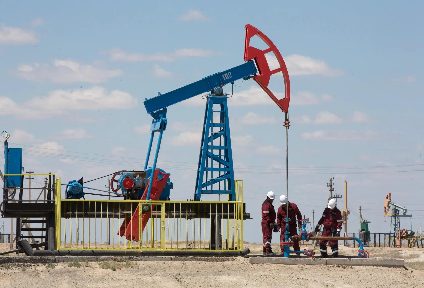 Workers perform maintenance on an oil pumping unit in Akkystau village, Kazakhstan.