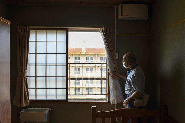 Toshio Ishikawa, a longtime KCM employee, helps to support trainees' daily lives look outside the window of an apartment building Kushiro, Hokkaido, Japan, on Friday, July 7, 2023. Photographer: Noriko Hayashi/Bloomberg