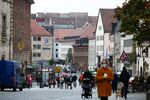 Pedestrians wear protective face masks near retail outlets on Burgstrasse in Nuremburg, Germany, on Monday, Oct. 19, 2020.