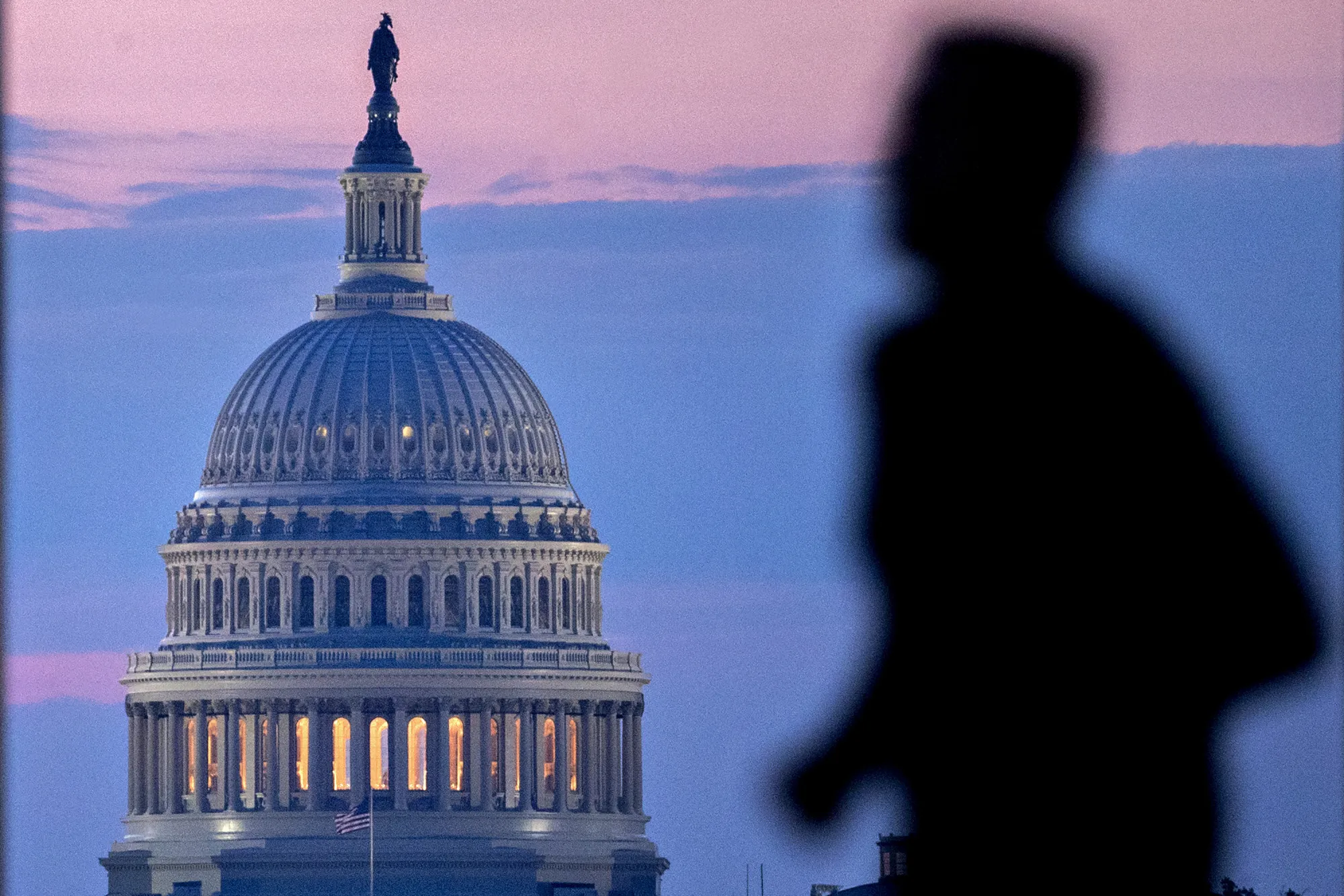 A runner passes the U.S. Capitol building before sunrise in Washington, D.C., U.S., on Tuesday, July 11, 2017. As Congress returned from its mid-summer break yesterday for a crucial three-week stretch, several obstacles await lawmakers, including an ongoing health-care fight, divisions among Republicans on the basic parameters of a tax bill, and a maelstrom of upcoming deadlines to keep the government running and avert a catastrophic default on U.S. debt.
