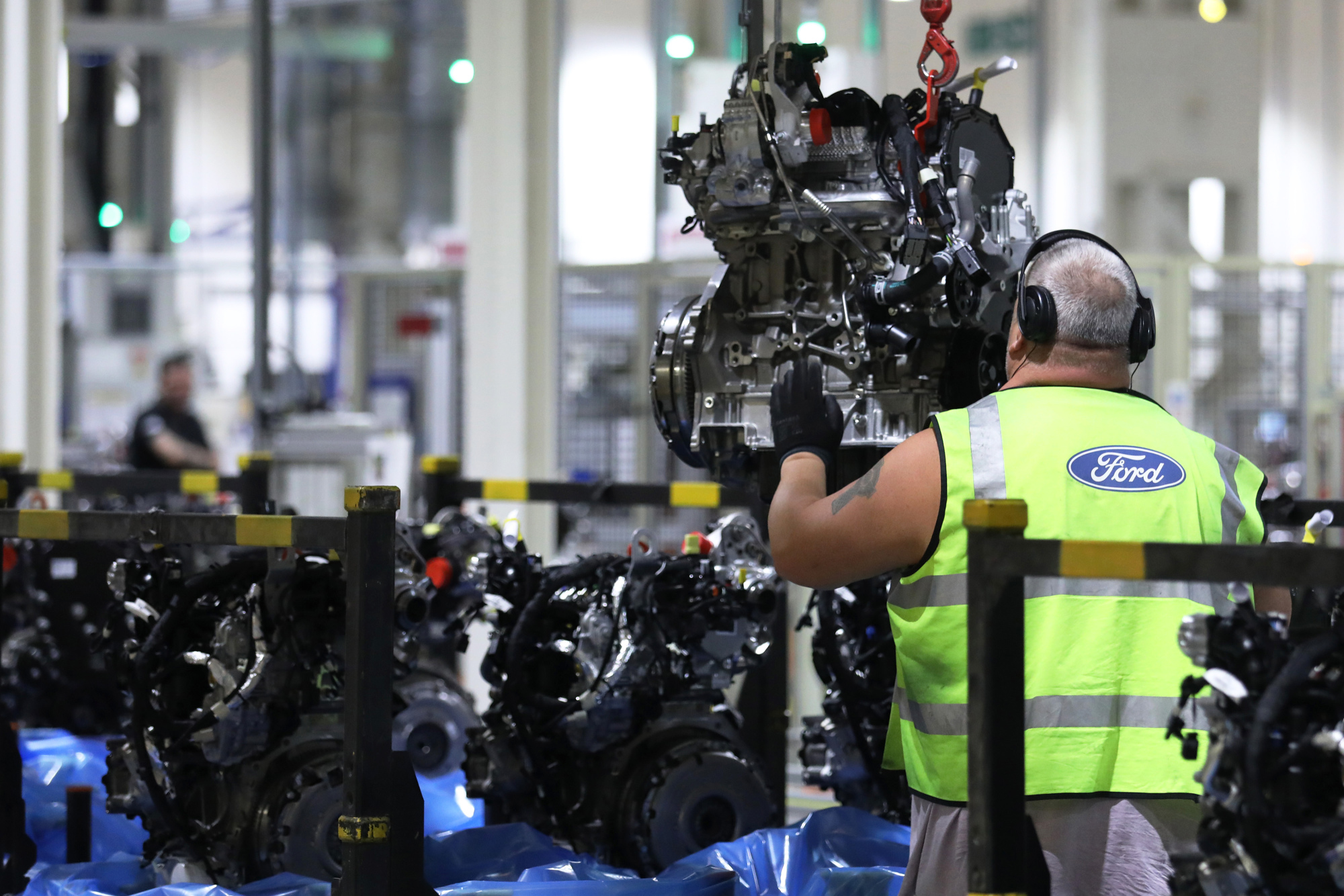 A worker removes an engine from the conveyor at the Ford Motor Co.’s engine assembly plant in Dagenham, U.K.