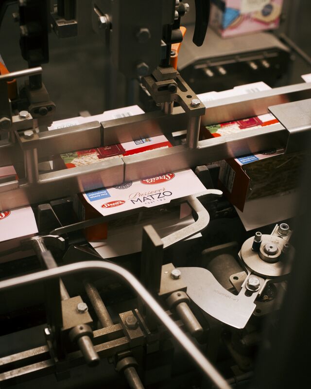 A Streit's Matzo packaging machine opens the flattened boxes and then fills them with wrapped stacks of matzos.
