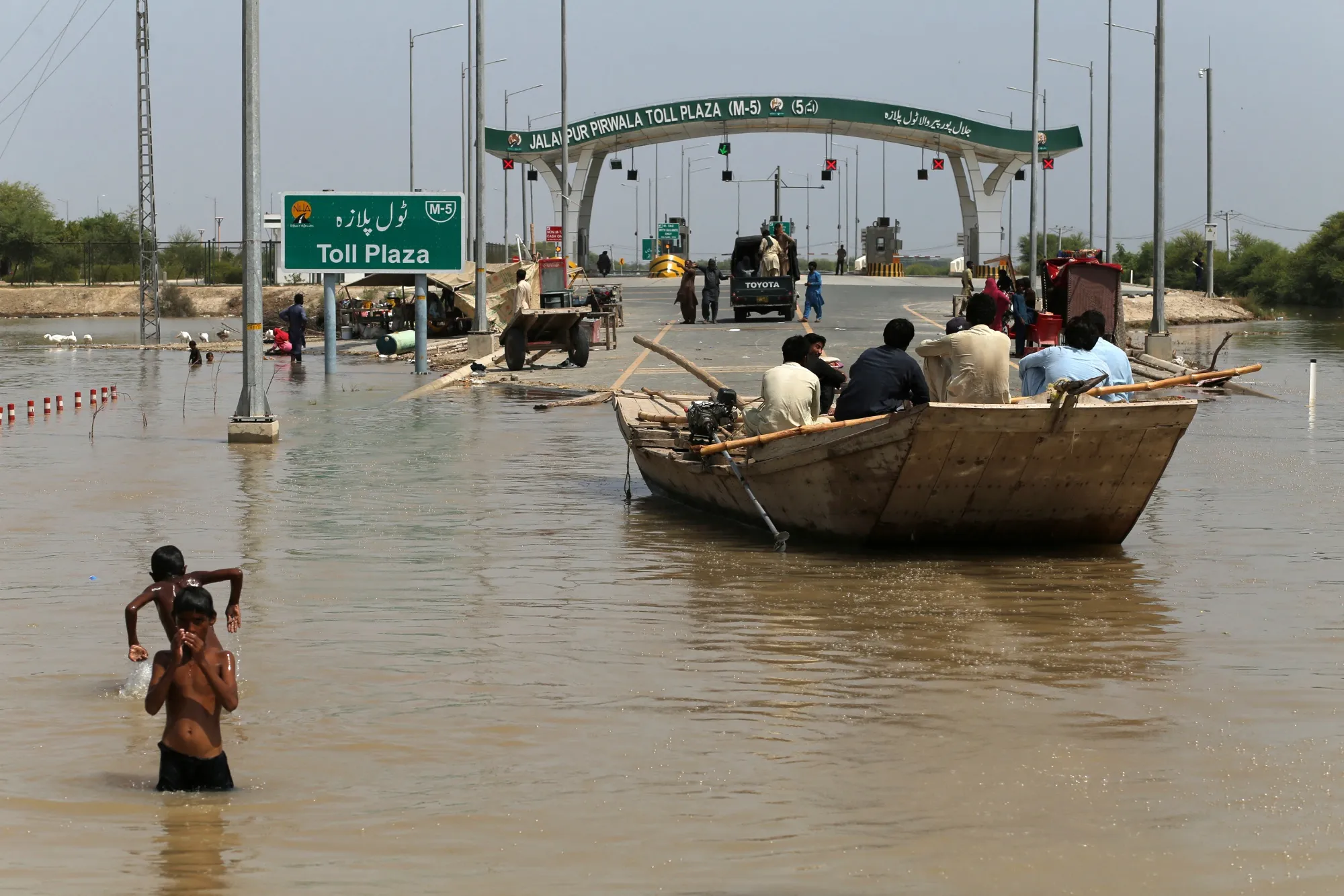 People use a boat to commute near the closed motorway following monsoon floods&nbsp;in&nbsp;Punjab province, on Sept. 17.