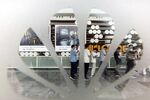 Employees standing in line at the canteen during lunch hour are seen through a Huawei Technologies Co. logo on a window at the company's headquarters in Shenzhen, China.