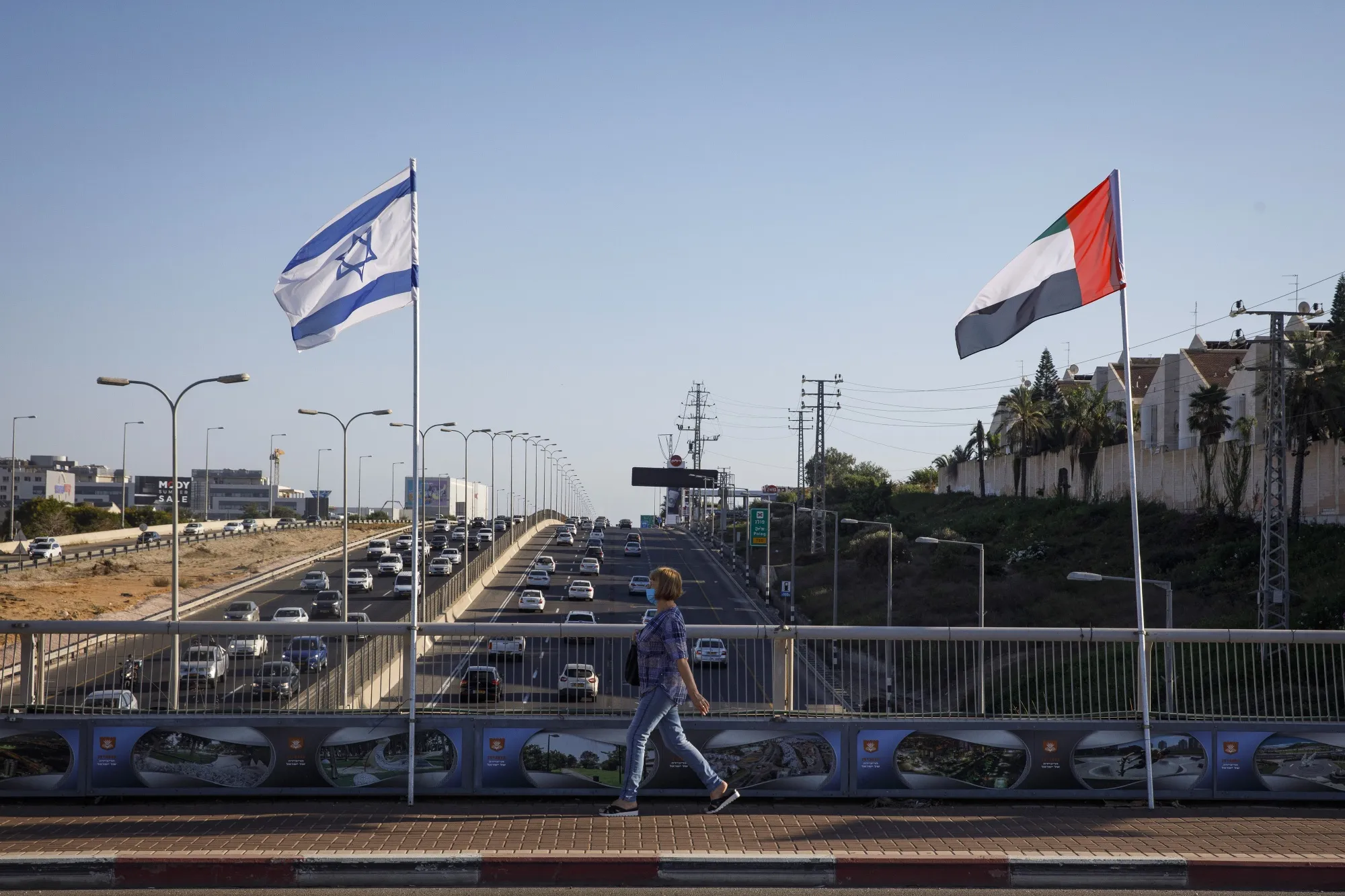 A pedestrian walks past&nbsp;an Israeli&nbsp;and a United Arab Emirates flags flying in Netanya, Israel,&nbsp;on Aug. 17.