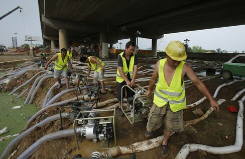 Workers handle pumps and tubes to drain off water in Wuhan, Hubei Province on July 11. Continuous heavy rainfall in south China has flooded many cities.