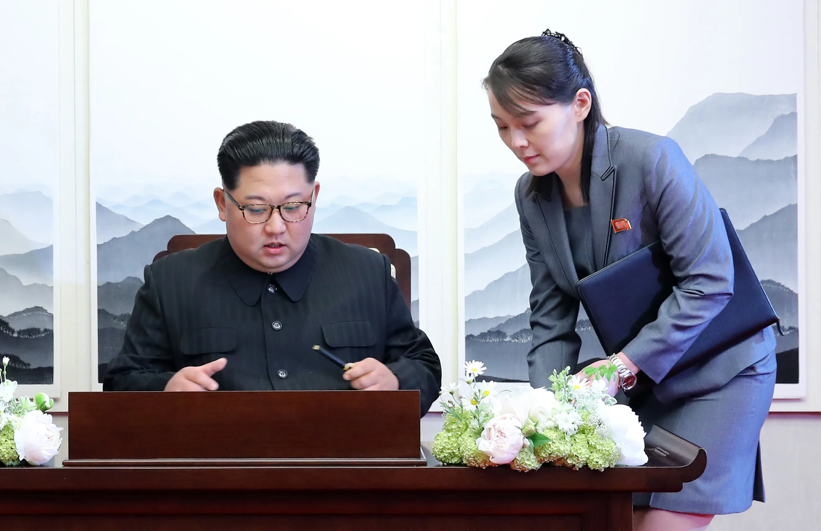 Kim Jong Un, North Korea's leader, prepares to write in a guestbook assisted by his sister Kim Yo Jong inside the truce village of Panmunjom in the Demilitarized Zone&nbsp;in South Korea&nbsp;on April 27, 2018.