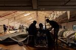 Employees work at a sewing machine, powered by a generator, during a load-shedding power outage period in Cape Town.