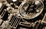 A coin representing Bitcoin cryptocurrency sits on a computer circuit board in this arranged photograph in London, U.K., on Tuesday, Feb. 6, 2018. 