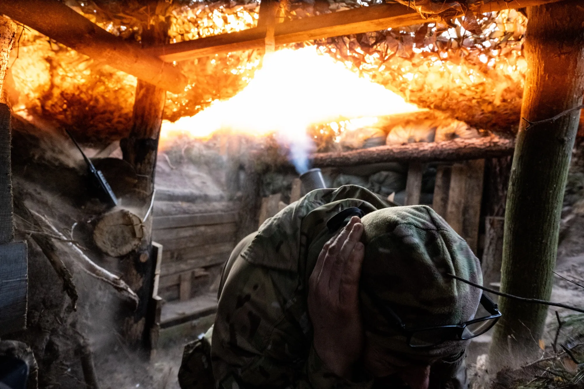 A Ukrainian soldier fires a mortar at Russian positions. 