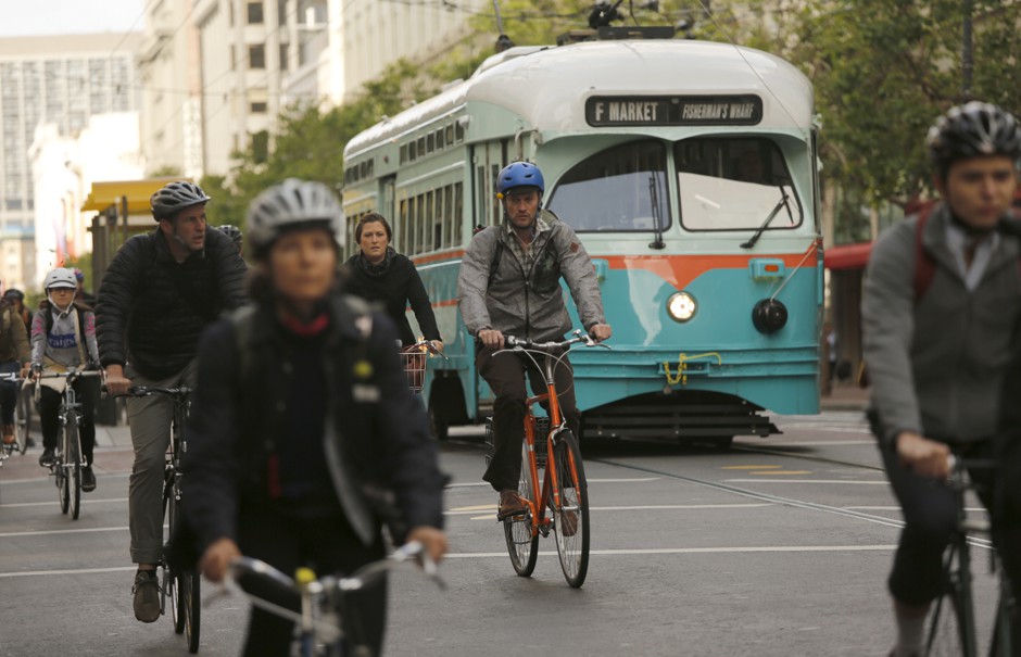 Cyclists ride beside a streetcar in the Mid Market neighborhood in San Francisco, California.