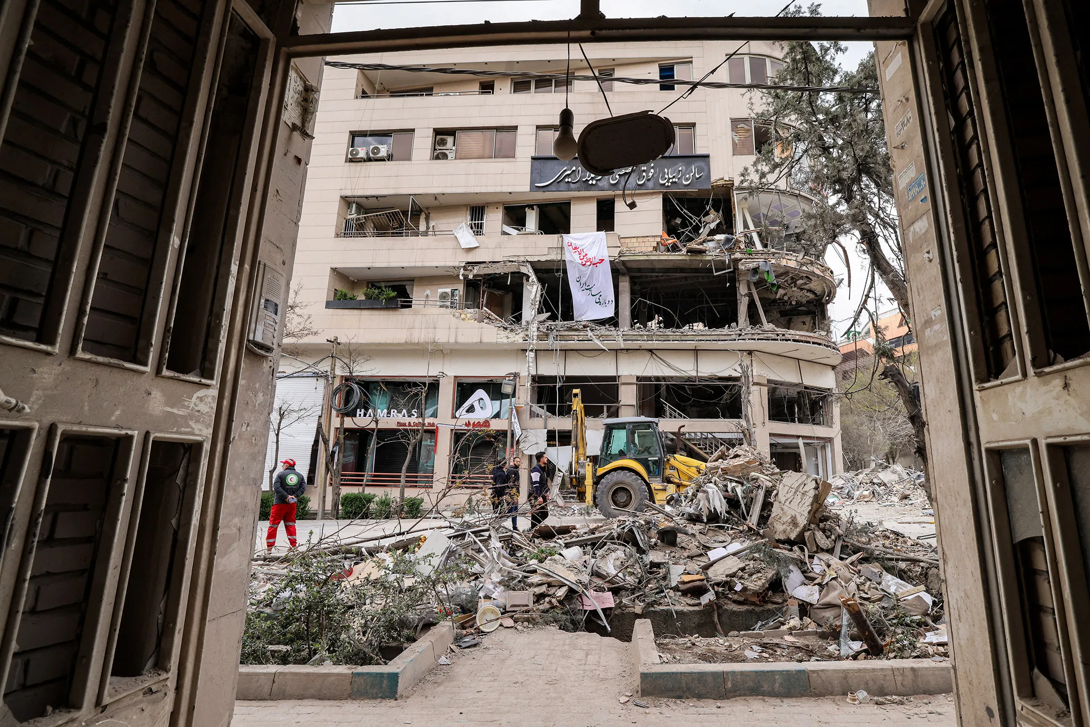 People inspect the destruction on the office building that housed&nbsp;the Doha-headquartered news network Al Araby TV following a missile strike earlier in the day, in Tehran on March 29.