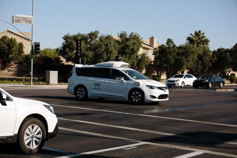 A Waymo autonomous vehicle passes through an intersection in Chandler, Ariz.