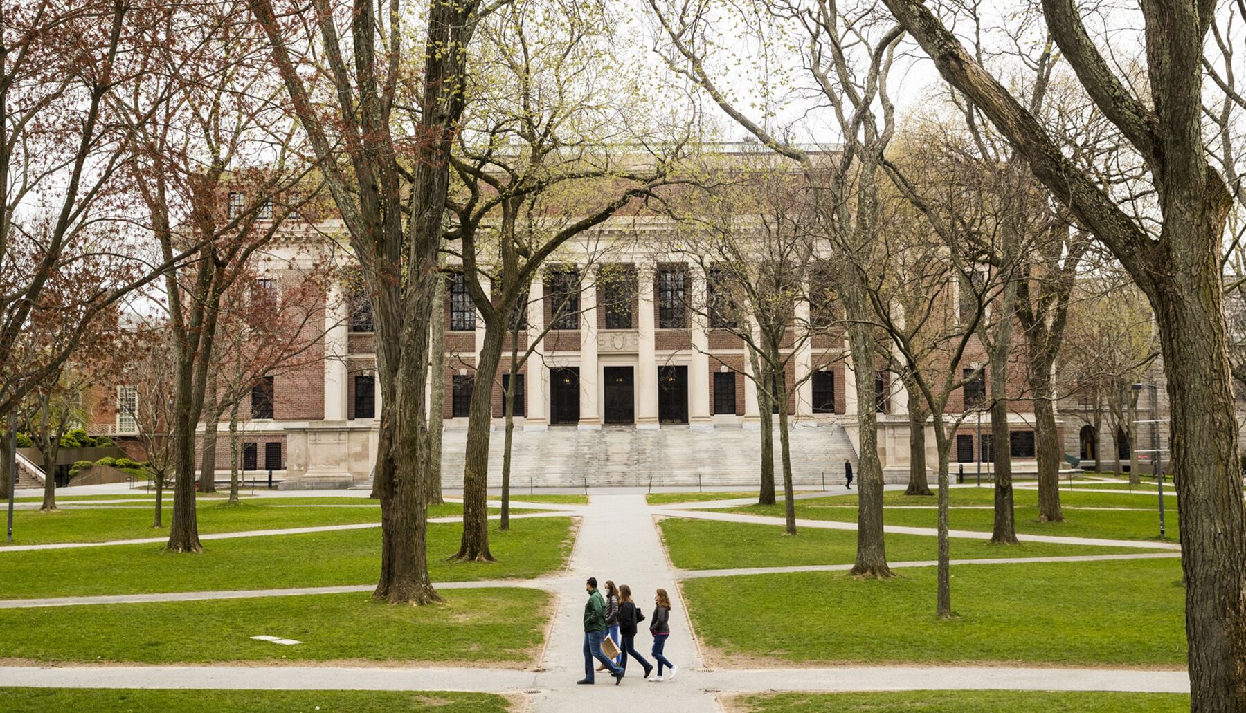 Pedestrians walk through Harvard Yard on the closed Harvard University campus in Cambridge, Massachusetts on April 20.