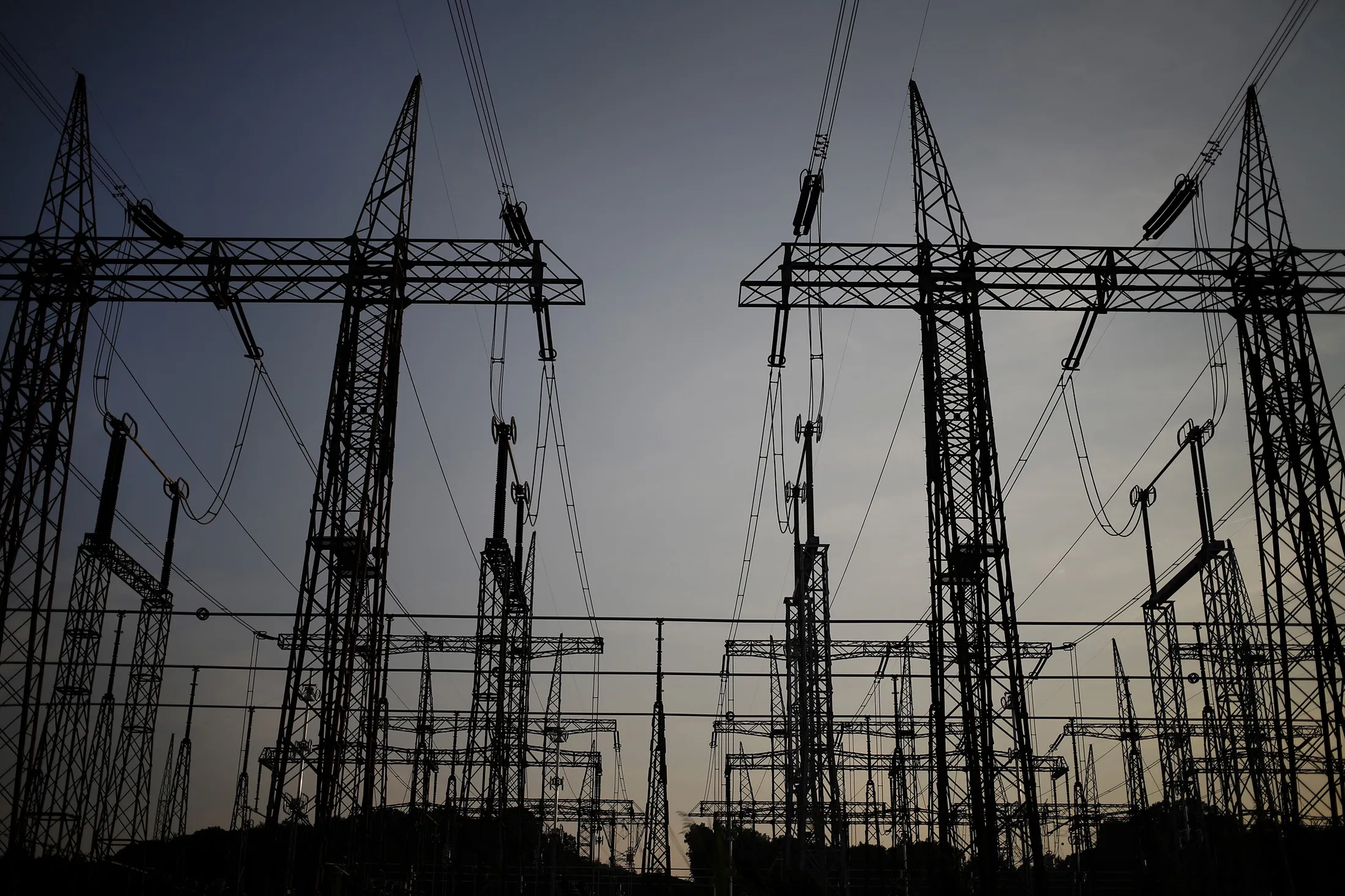 The silhouette of power lines are seen standing at the American Electric Power Co. Inc. coal-fired John E. Amos Power Plant in Winfield, West Virginia, on July 31, 2014.
