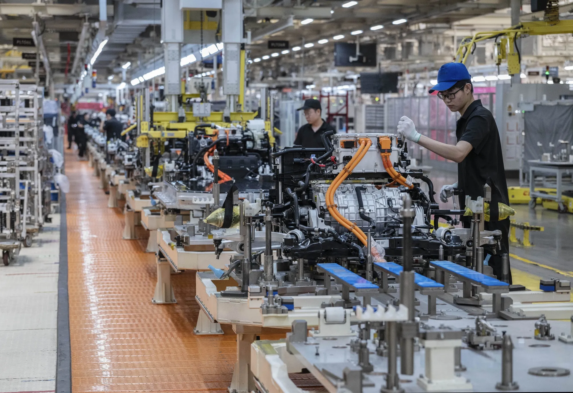 A worker assembles parts for vehicles on the production line for electric vehicles at a factory in Ningbo, China.