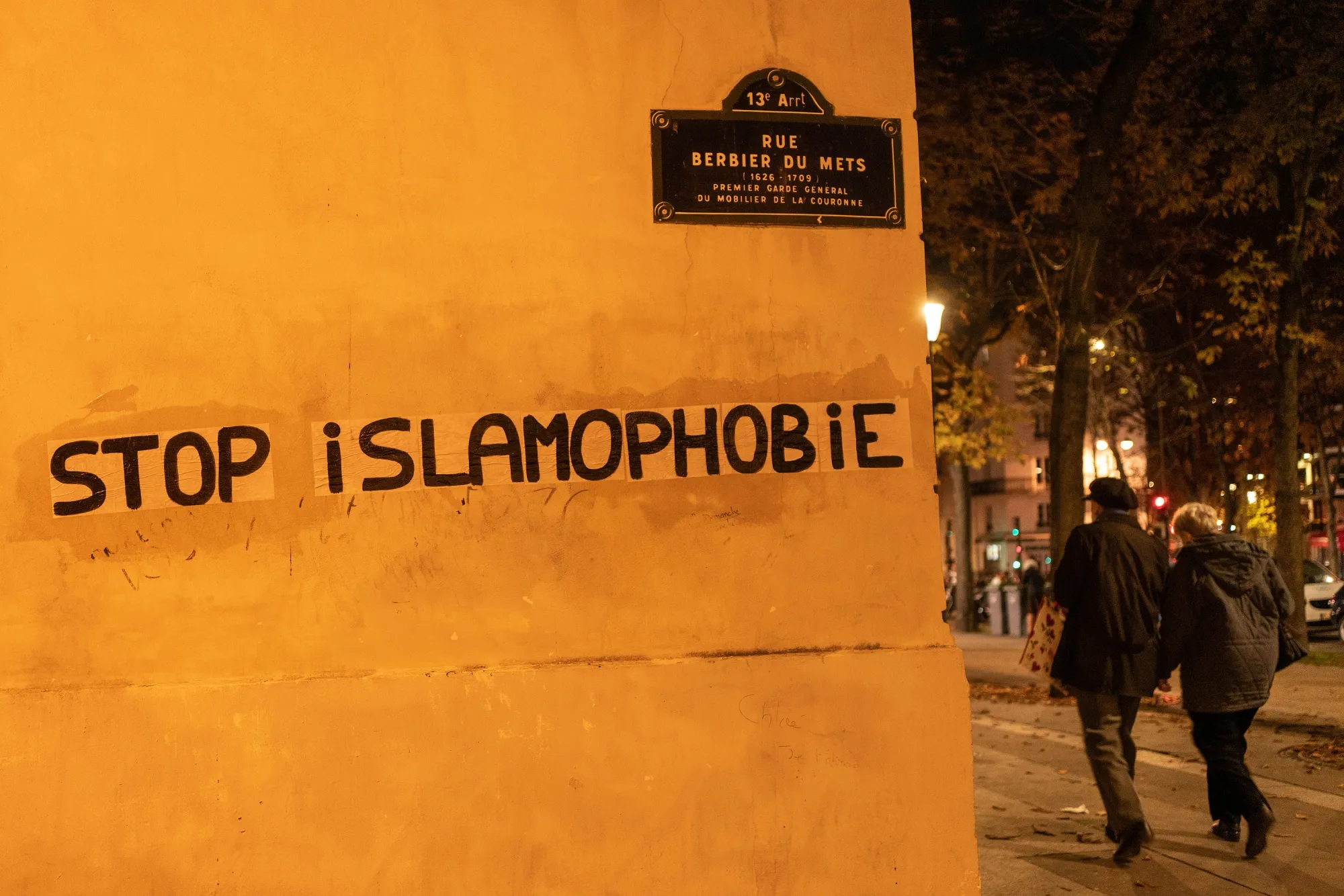 People walk past graffiti&nbsp;reading&nbsp;‘Stop Islamophobia’&nbsp;in Paris, France.