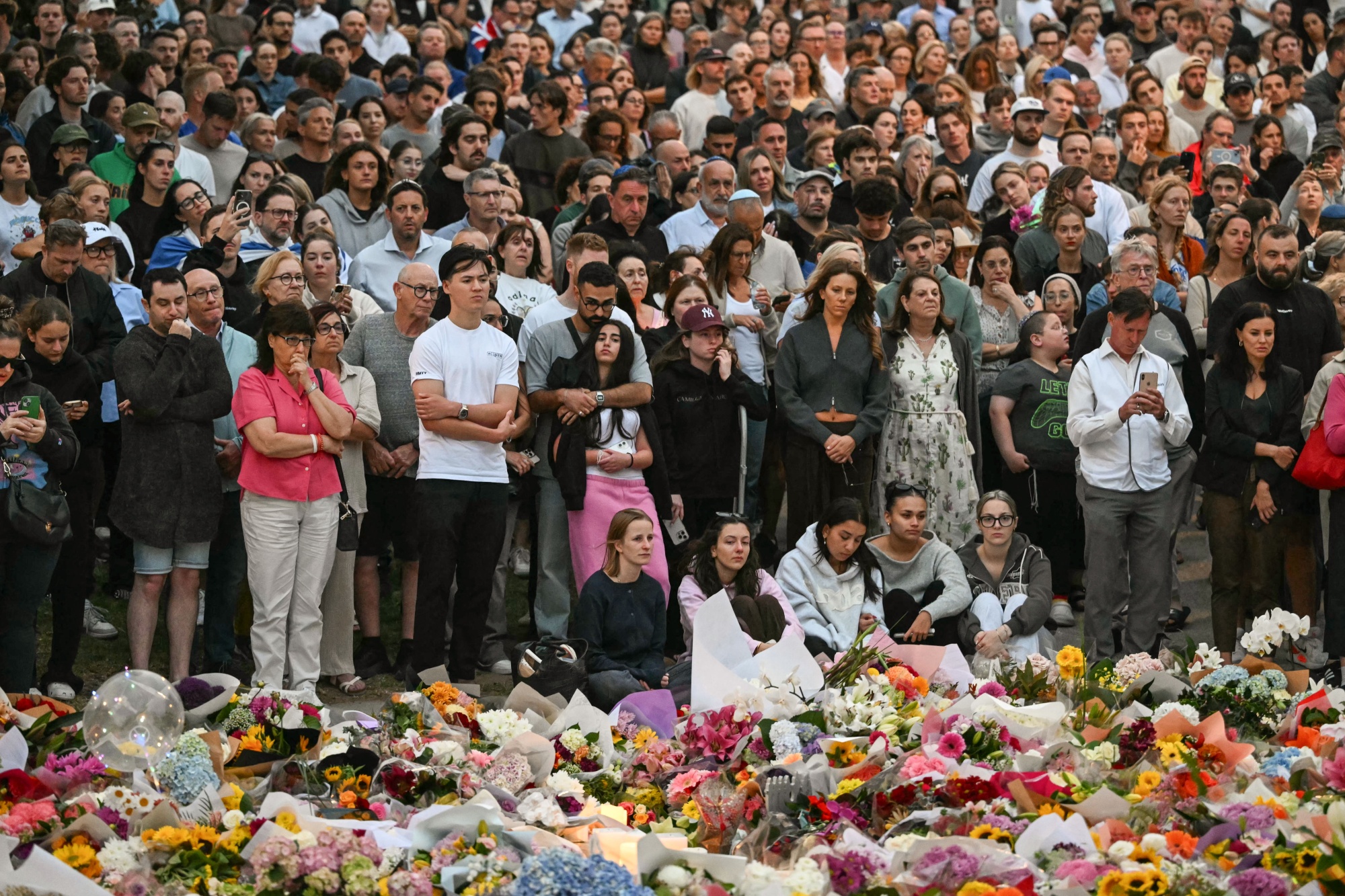 Mourners gather at a tribute at the Bondi Pavillion in memory of the victims of a shooting at Bondi Beach, in Sydney on December 15, 2025. A father and son opened fire on a Jewish festival at Australia's Bondi Beach in a shooting spree that killed 15 people, including a child, authorities said on December 15, denouncing the attack as antisemitic "terrorism". (Photo by Saeed KHAN / AFP via Getty Images)