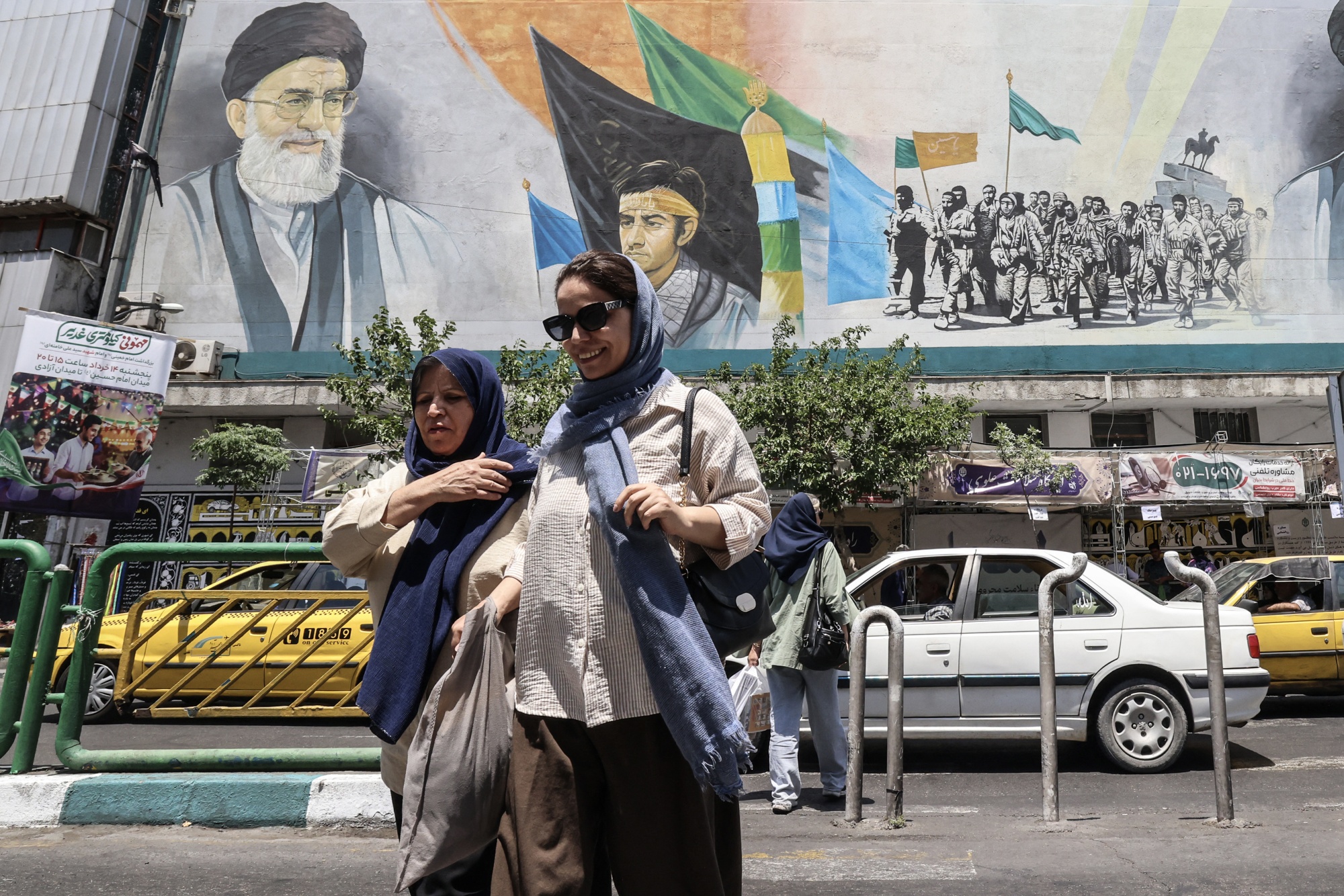 Women walk through Enghelab Square in Tehran on June 3. Photographer: Atta Kenare/AFP/Getty Images