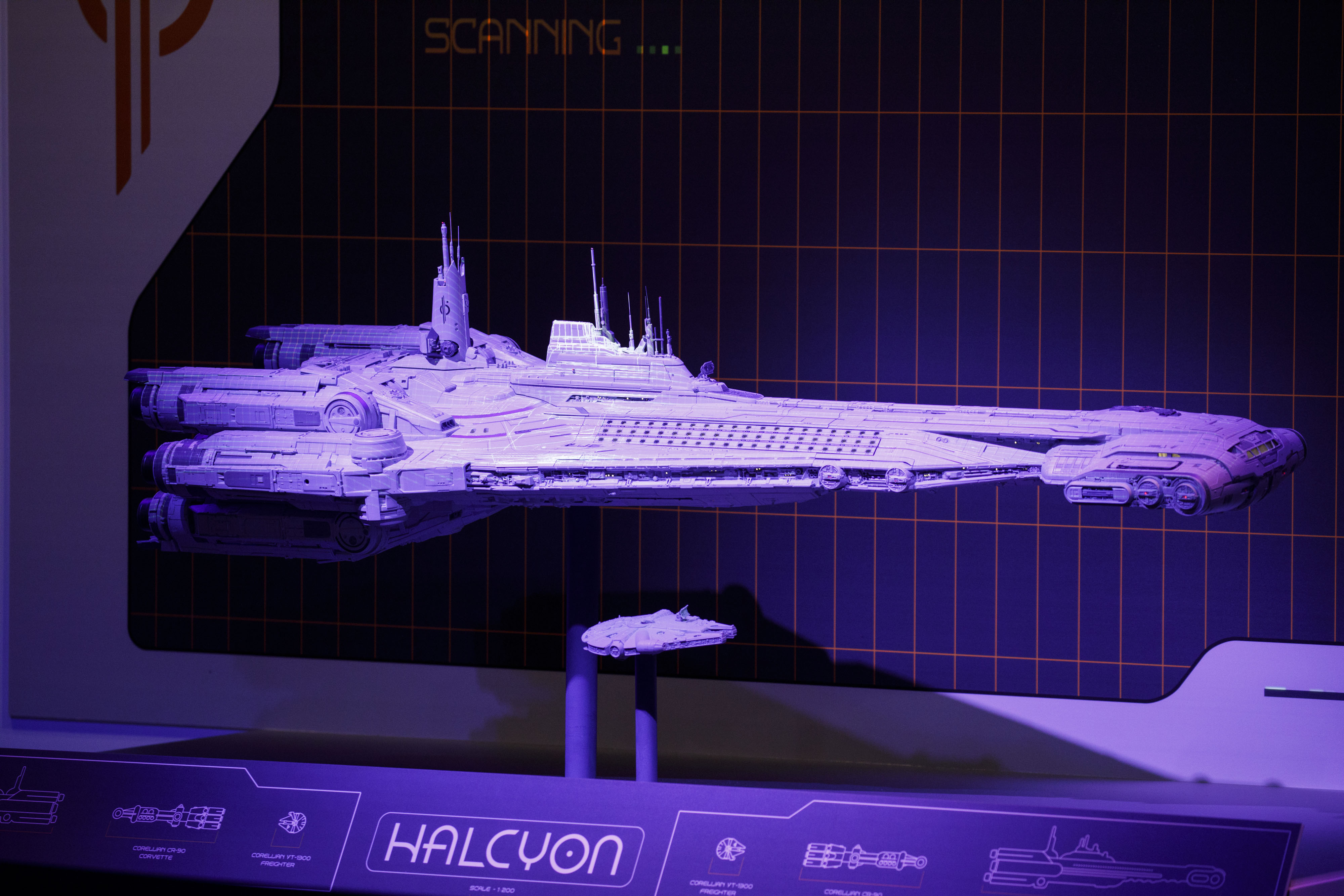 A model of the Millennium Falcon stands beneath a model of the Halcyon ship.