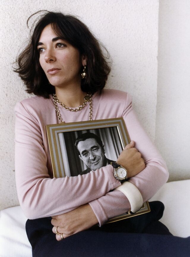 Maxwell holds a framed photograph of her late father in Jerusalem in 1991. 