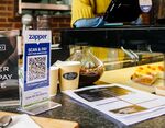 A Zapper 'Scan &amp; Pay' QR code for mobile payment on the counter in a cafe in Johannesburg.