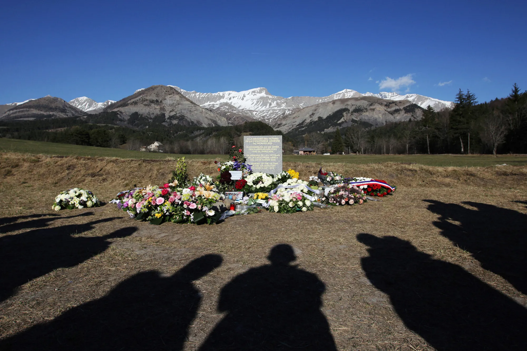 People stand near a memorial commemorating the victims of the Germanwings Airbus A320 crash in the village of Le Vernet, southeastern France, on April 6, 2015.
