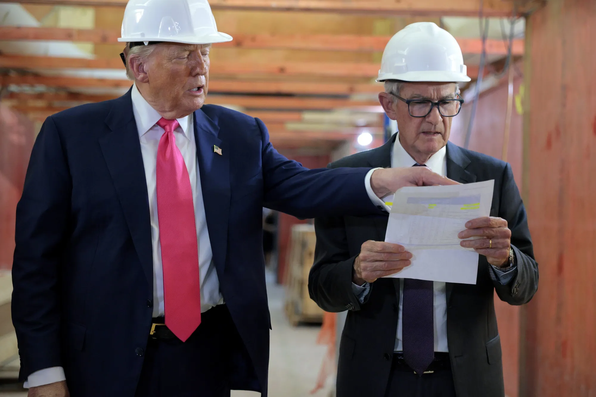Trump and Powell tour the $2.5 billion Fed renovation project in 2025 and review a document side by side.