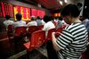 An investor knits while watching stock quotes at a securities trading firm in Shanghai, China, on Thursday, July 15, 2010. China's stocks dropped, led by commodity producers, after the nation's economic growth slowed in the second quarter.