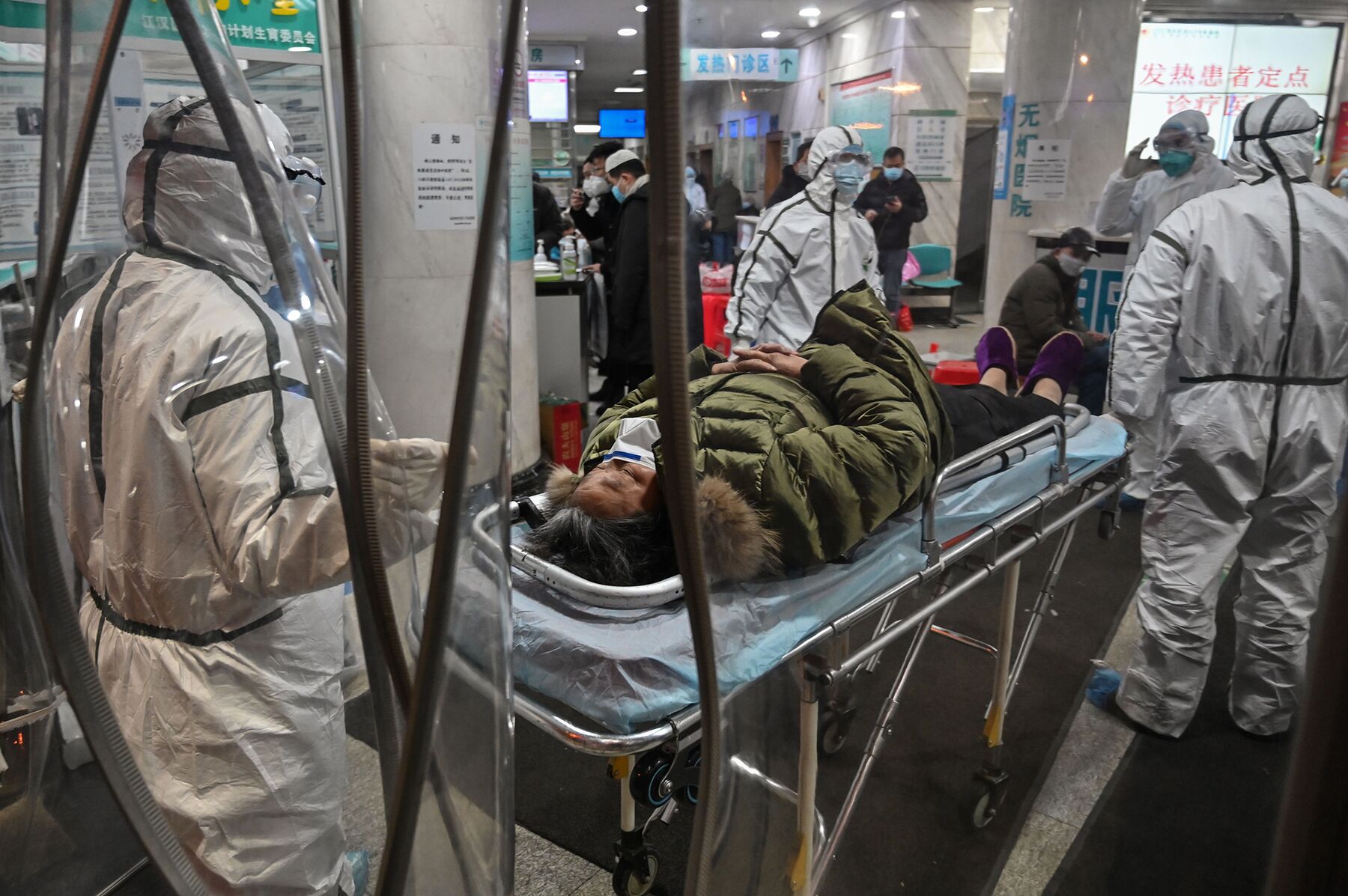 Medical staff members wearing protective clothing arrive with a patient at the Wuhan Red Cross Hospital in Wuhan on Jan. 25.