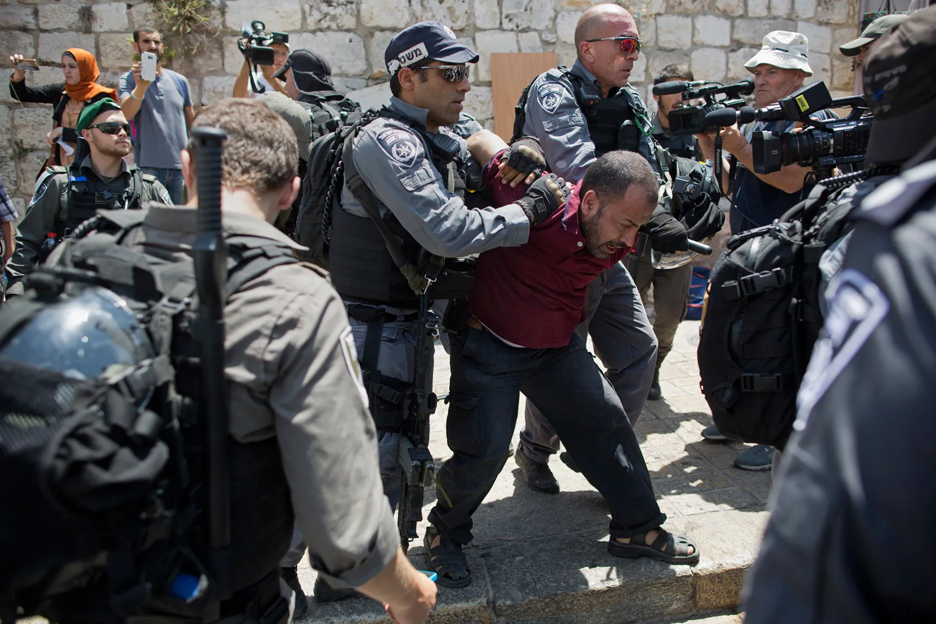 Israeli police officers detain a Palestinian man outside the Lion's Gate in Jerusalem's Old City, Wednesday, July 19, 2017.
